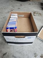 Wide view of cardboard box labeled 'Basketball Cards' partially filled with trading cards standing vertically.