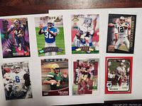 Front view of all eight football cards showing player images including Shannon Sharpe, Michael Irvin, Kerry Collins, Trey Lance, and others.