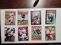 Eight football trading cards laid out on table front side visible showing player images.