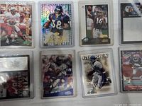 Photo showing front of 8 football cards in plastic sleeves featuring various players and designs