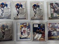 Front view of football cards featuring multiple players including OJ Simpson, Drew Bledsoe, and others in protective sleeves.