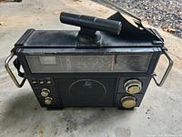 Front view of a black Realistic SW-100 short wave radio with antenna and control knobs visible.
