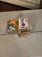 Stack of assorted football sports cards in protective sleeves.