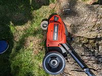 Top down view of the electric edger showing Black & Decker branding and part of the housing and wheels on grass.