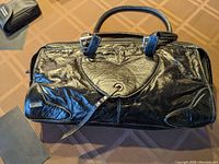 Full view of the black leather Roberto Cavalli handbag showing shape, size, and top handles.