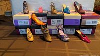 Full view of 10 decorative shoe figurines displayed on their original boxes, showing colors, styles, and condition.