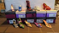 10 assorted women's shoes displayed on top of their original Poetic License branded boxes. Shoes include heels, boots, sandals, and slip-ons. Various colors and styles shown.