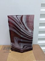 Side view of the hexagonal deco-shaped vase with purple and white swirls.