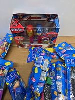 Boxed 3-pack Avengers PEZ dispensers with Iron Man and Captain America, plus loose sealed PEZ dispensers in original packaging.