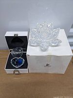 Photo showing both the Swarovski large crystal lotus candle holder and the white box with heart-shaped crystal trinket box with colorful crystals inside.