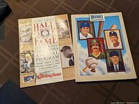 Two vintage baseball Hall of Fame induction ceremony programs placed on a table, showing front covers.