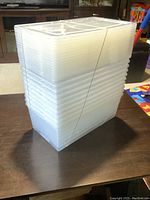Stack of 10 translucent plastic Kris storage containers bound with rubber bands, showing size and uniformity.