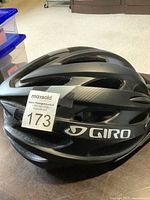 Side view of black Giro bike helmet showing brand logo and ventilation slots.