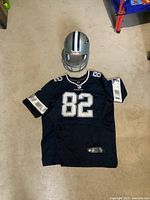 Jersey laid flat on floor with helmet above, showing both items