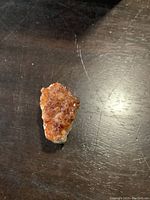 Top view of the amber colored crystal cluster on dark surface.