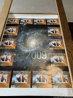 Full view of the 2009 International Year of Astronomy uncut stamp sheet showing all 14 souvenir sheets attached on a cosmic galaxy background.
