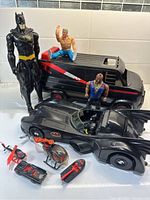 Photo of Batman and A-Team figures with vehicles including Batmobile and A-Team van.