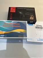 Three boxed detection devices including a bug detector, air quality detector, and a Weal device
