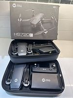Photo of Holy Stone HS720E drone and accessories in carrying case placed next to box