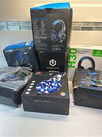 Lot of 7 gaming headphones in original boxes showing product packaging and designs