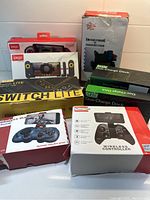 Overview of the gaming accessories including Nintendo Switch Lite, Ipega wireless controllers, and charging docks in their boxes arranged on a white surface.