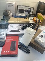Photo showing various boxed and loose electronic items including Star G430S tablet and an orange infrared thermometer.