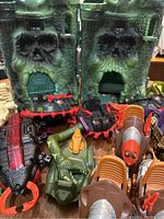 Overview of multiple MOTU vehicle parts including castle halves, crocodile hull, turret tops, drill vehicles, magenta hulls and clamp body