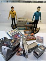 Full lot showing Star Trek figures of Kirk and Spock, Enterprise Shuttlecraft toy, phaser, playing cards, and Star Trek books.