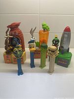 Front view of 7 PEZ dispensers showing all character designs and overall condition with light scratches.