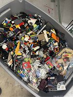 Overhead view of plastic tub filled with loose LEGO and Mega Bloks pieces