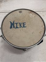 Top view of drumhead showing name 'Mike' and Remo logo.