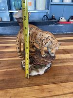 Side angle of the porcelain leopard decanter with measuring tape showing approximately 10 inches tall.