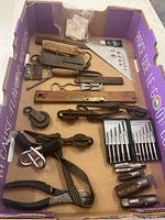 Full view of all tools showing various antique hand tools, rulers, screwdrivers, pulleys, and cutting tools.