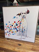 Full view of the framed square oil painting showing a white dog with colorful paint spots around it.