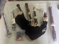 Overview of all disassembled bagpipe components laid out on table