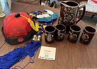 Tea set, hat, and hanging decor shown together on table