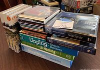 Stack of various audio CDs including a boxed set labeled with volumes and individual titles focused on healing and spirituality.
