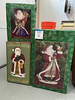 Original boxes for the two Dillards Trimmings Santas and the Victorian Santa cookie jar, showing product names and packaging condition.