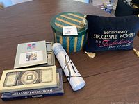 Overall photo showing pillow, round stacking boxes, vinyl wall art roll, photo trivets and picture frames on a table