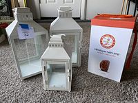 Three decorative lanterns (2 large, 1 medium) made of white metal with glass panels alongside the boxed Himalayan salt lamp.