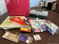 Overview of craft supplies including markers, paints, glues, rulers, and scrapbooking materials on a table.