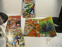 Five Marvel comic books arranged on table showing cover art for Spider-Man, Captain America, and Sub-Mariner