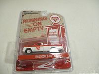 Front packaging view showing the diecast 1965 Dodge D-100 truck model with Conoco logo and setup.
