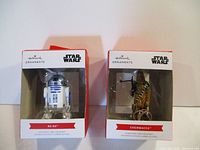 Photo showing boxed R2-D2 and Chewbacca Hallmark Star Wars Christmas ornaments side by side
