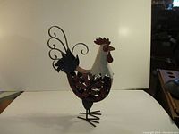 Full view of metal rooster sculpture showing its shape and standing position.