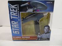 Front view of the boxed Star Trek Classic Phaser toy with Star Trek branding and Captain Kirk image.