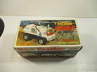 Full box image of vintage Moon Grabber battery operated toy by Marx with lunar rover styling and moon terrain background graphics