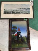Both framed artworks side by side on the floor showing the painted glass landscape lower and the Harbour Grace Newfoundland print above.
