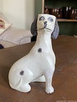 Spotted dog hand carved in basswood, painted white with black spots, sitting pose