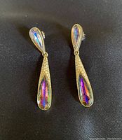 Pair of Oscar de la Renta gold-tone teardrop earrings with rhinestones and multicolored crystals set on a black background.